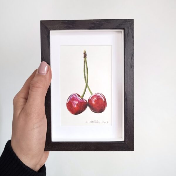 Hand holding a framed charming cherry duo illustration