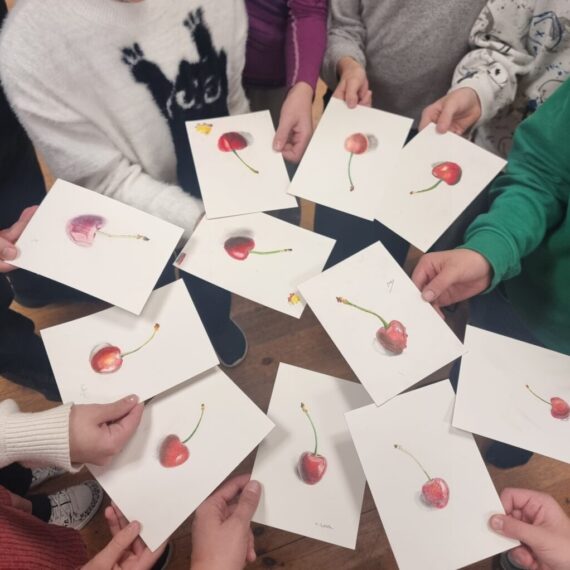 Children hands holding cherry drawing